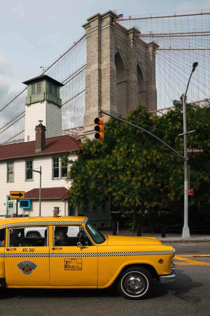 old taxi car with the Brooklyn Bridge in the backdrop in DUMBO Brooklyn