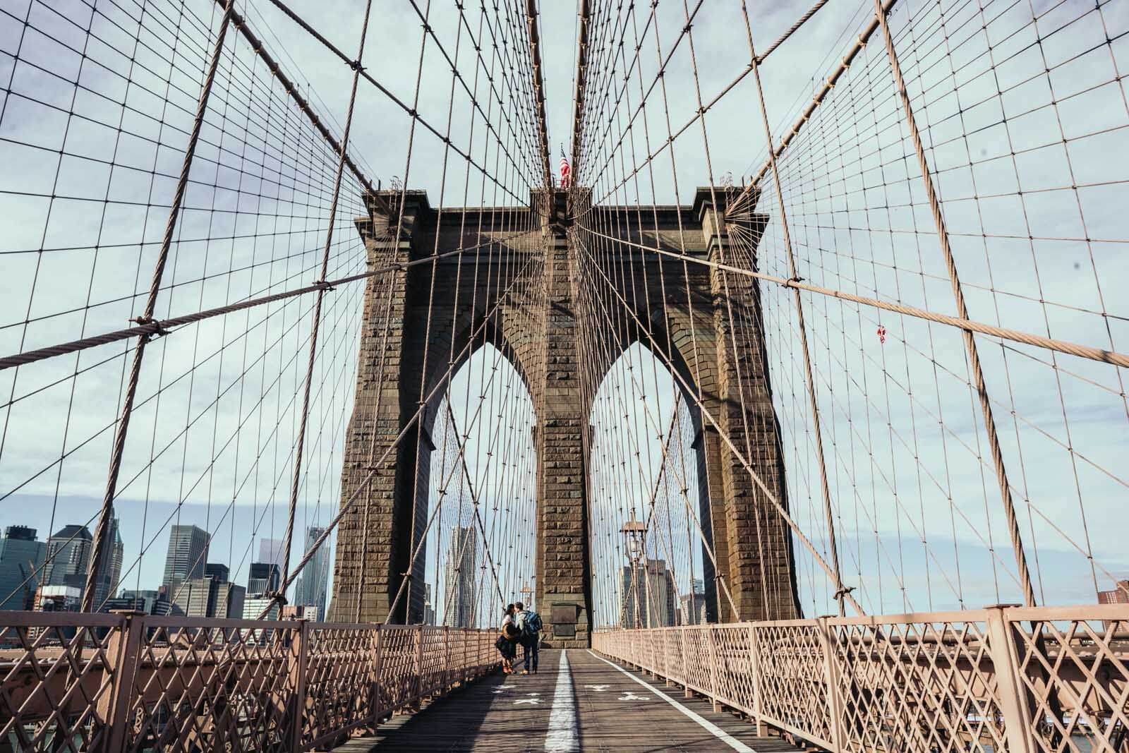 a couples kiss on the Brooklyn Bridge