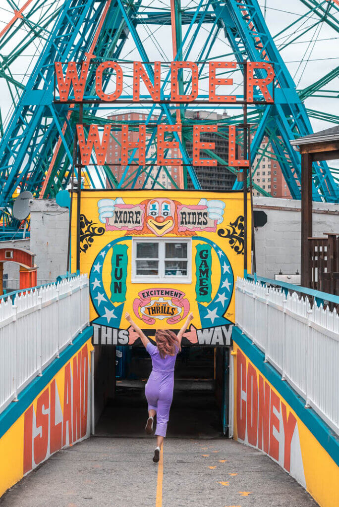 skipping for joy toward Denos Wonder Wheel at Coney Island Amusement Park in Brooklyn