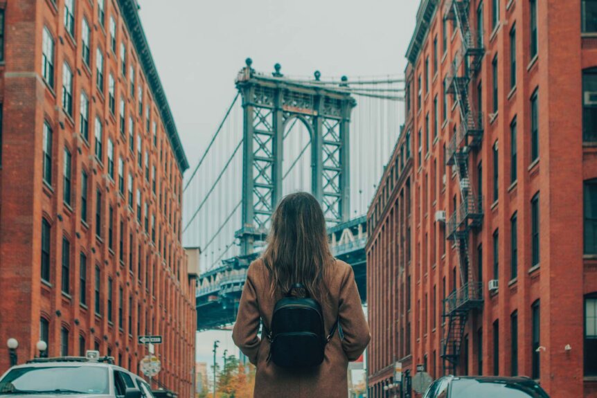 girl looking at Manhattan Bridge from DUMBO Washington Street