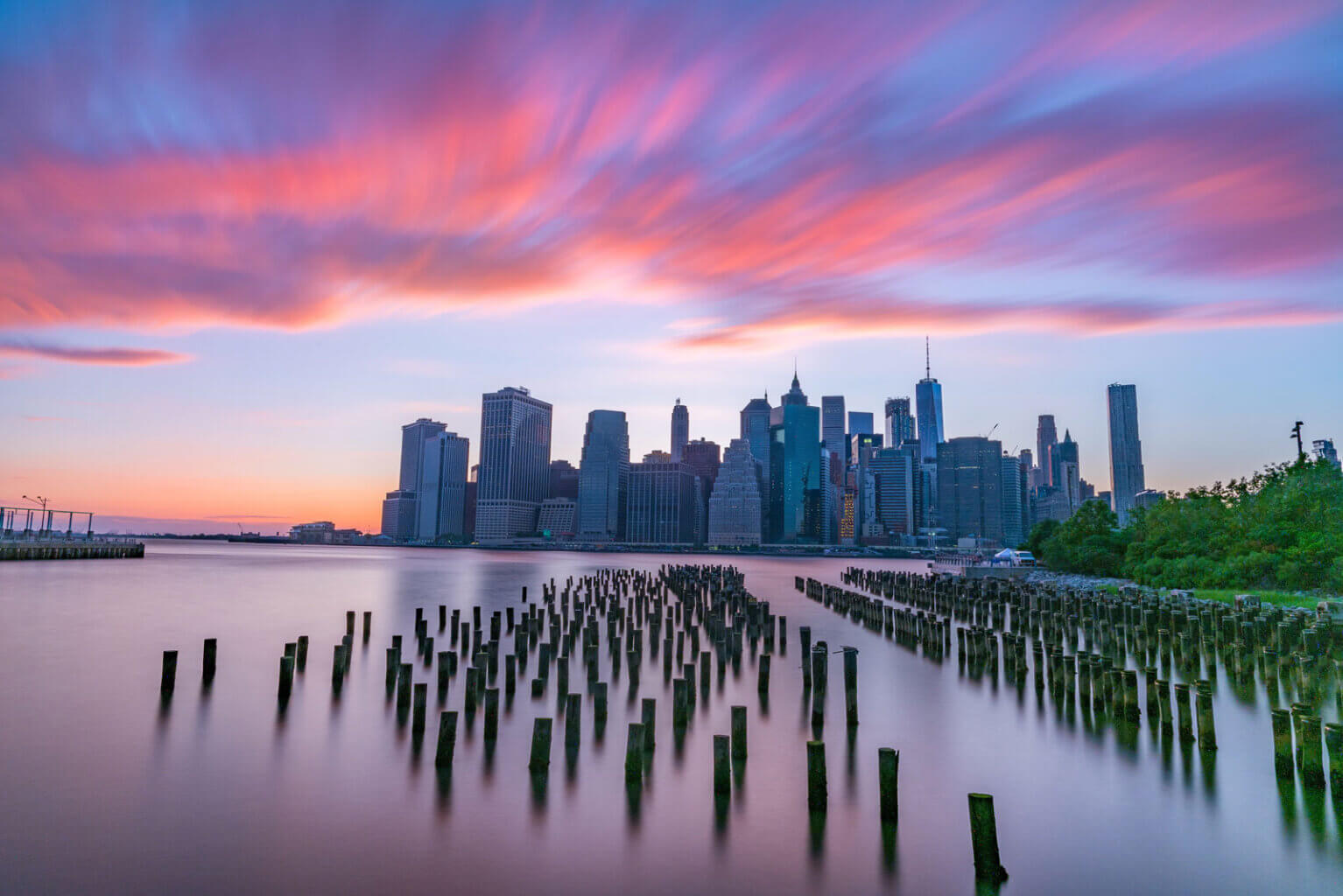 Iconic image of Manhattan Skyline During Sunset with Poles in the water