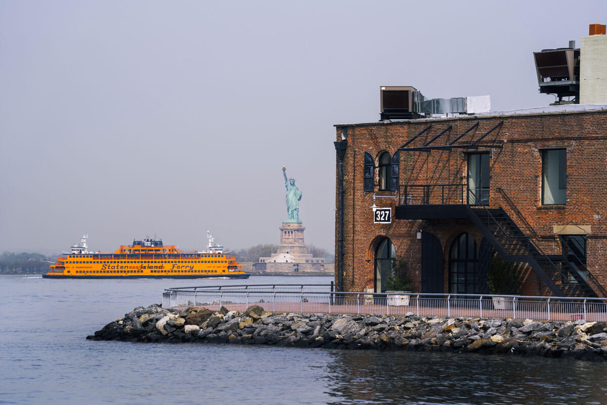 staten-island-ferry-next-to-statue-of-liberty-in-new-york-harbor-view-from-red-hook-brooklyn