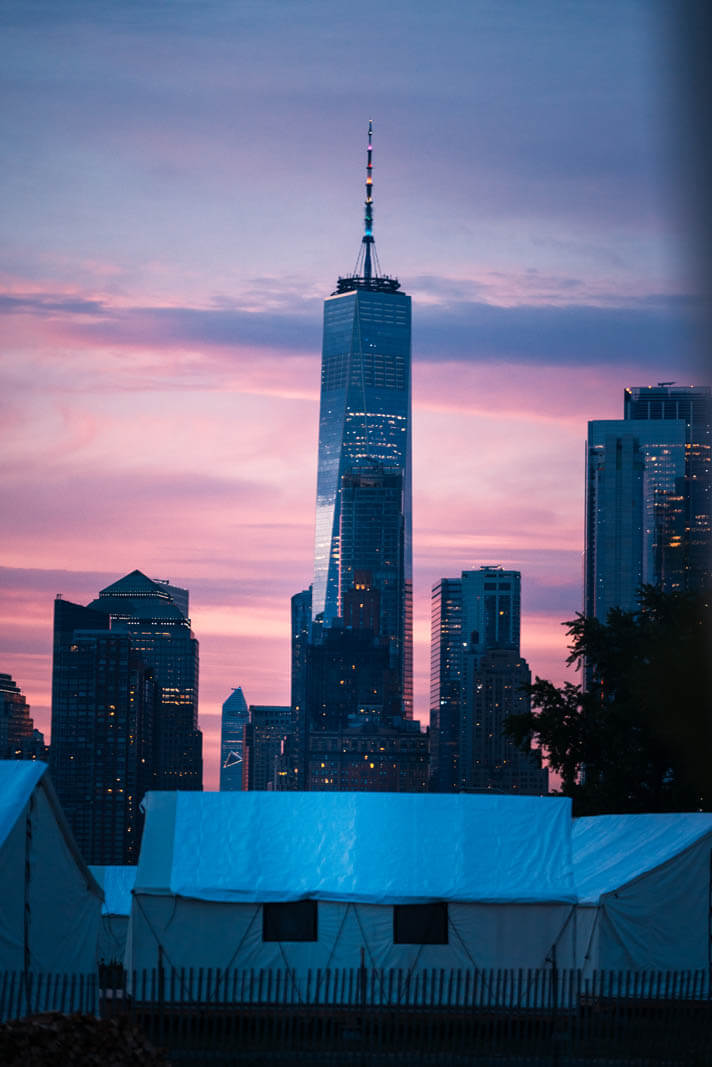 view of the World Trade Center from glamping at Collective Retreats Governors Island at sunset