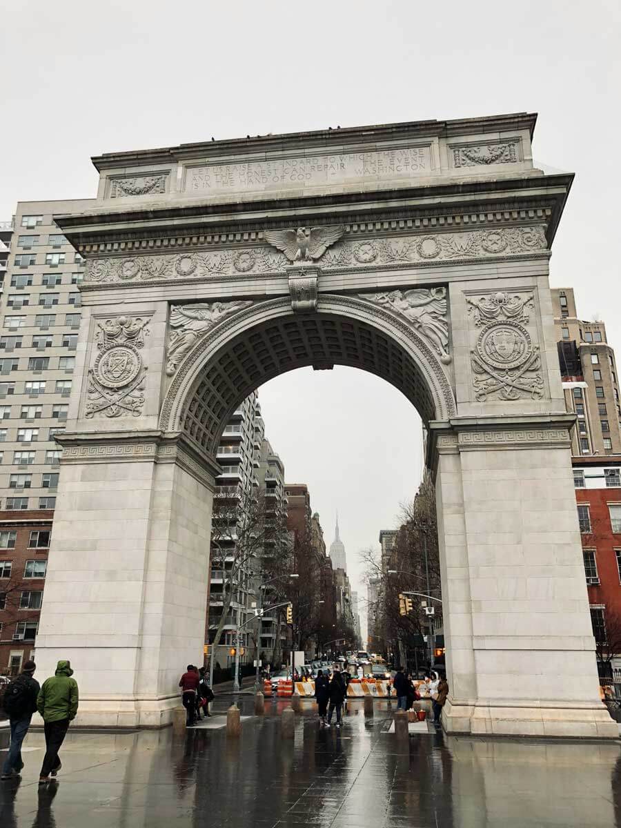 rainy-day-at-washington-square-park-with-the-empire-state-building-under-the-arch-in-NYC