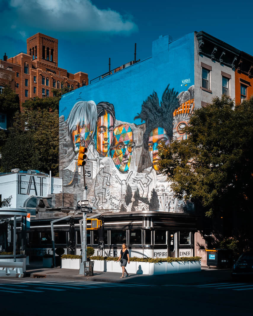 Old School American diner in New York Empire Diner with colorful Kobra Mural above it in Chelsea NYC