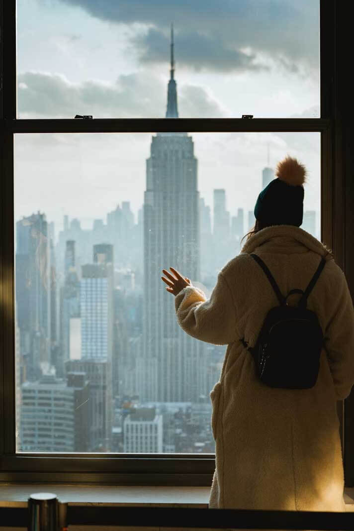 view of Empire State Building through the window at Top of the Rock in NYC