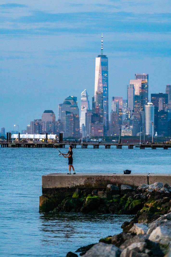 fishing along the waterfront in Bay Ridge in Brooklyn with a view of the World Trade Center in the background