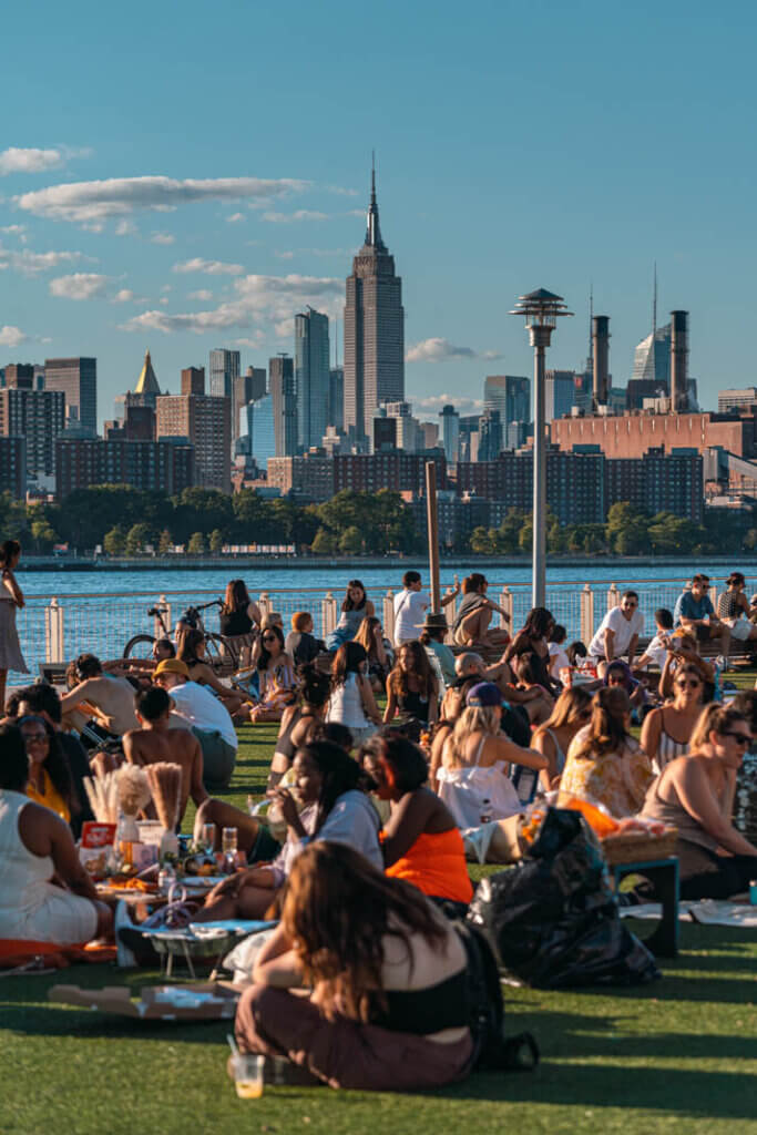 view of Empire State Building from Domino Park in Williamsburg in the summer