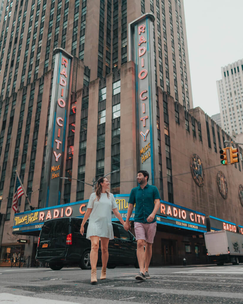 couple-crossing-the-street-in-front-of-Radio-City-Music-Hall-in-Midtown-Manhattan-NYC
