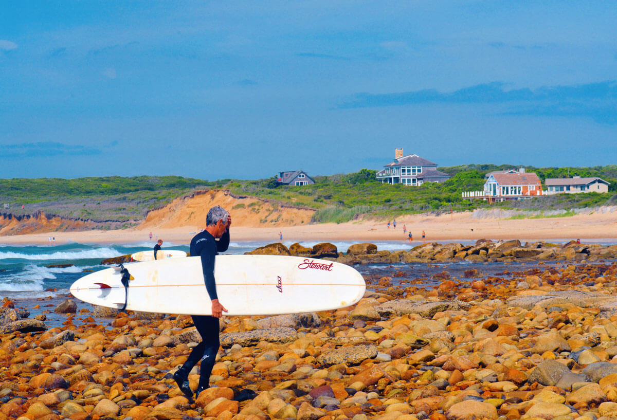 surfer-at-Ditch-Plains-Beach-in-Montauk,-NY-one-of-the-most-popular-beaches-in-the-Hamptons-for-surfing