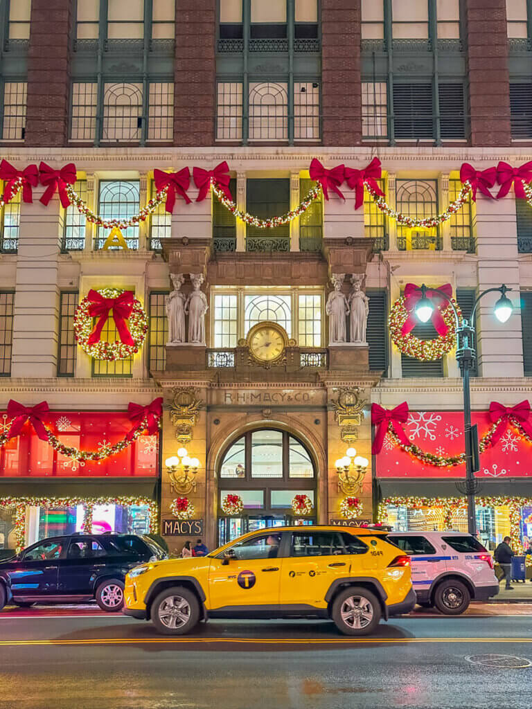 Macy's-Herald-Square-decorated-for-Christmas-with-a-taxi-on-34th-Street-in-NYC